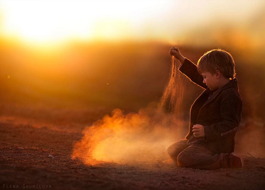 Child playing with sand at sunset on a Russian farm, creating a magical scene. Child playing with sand at sunset on a Russian farm, creating a magical scene.