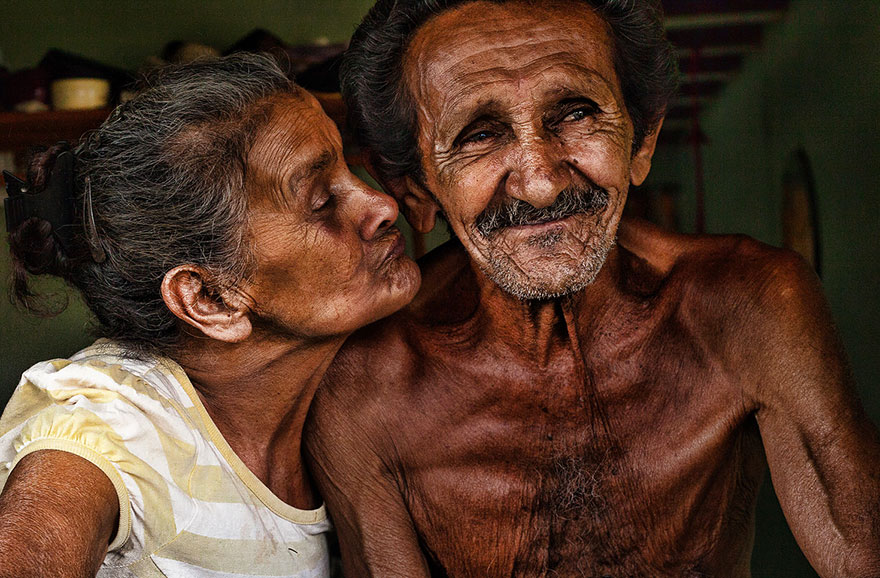 an old woman trying to kiss an old man into his cheek an old woman trying to kiss an old man into his cheek