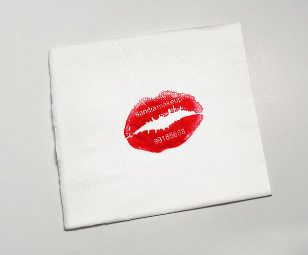 Creative business card featuring a lipstick print on a napkin with contact details. Creative business card featuring a lipstick print on a napkin with contact details.