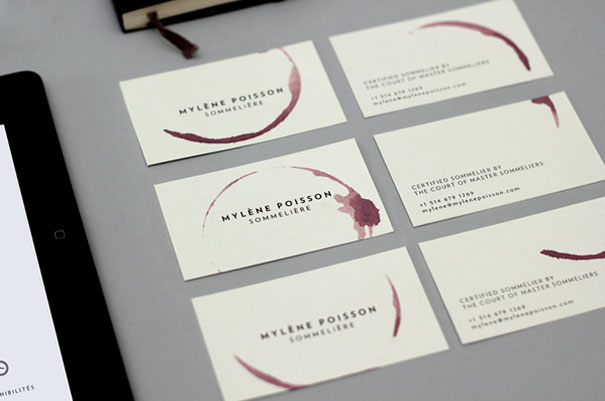 Creative business cards with wine stain design for a sommelier named Mylène Poisson, arranged on a gray surface. Creative business cards with wine stain design for a sommelier named Mylène Poisson, arranged on a gray surface.