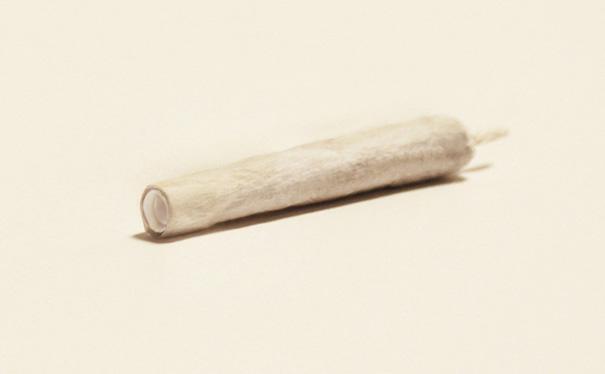 A creative business card designed as a rolled cigarette on a neutral background. A creative business card designed as a rolled cigarette on a neutral background.