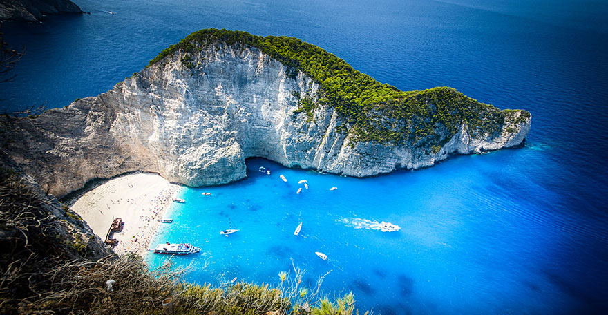 Navagio Bay with boats and person, Greece Navagio Bay with boats and person, Greece