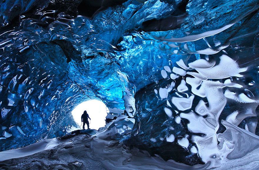Person walking in Vatnajokull Glacier Cave, Iceland Person walking in Vatnajokull Glacier Cave, Iceland