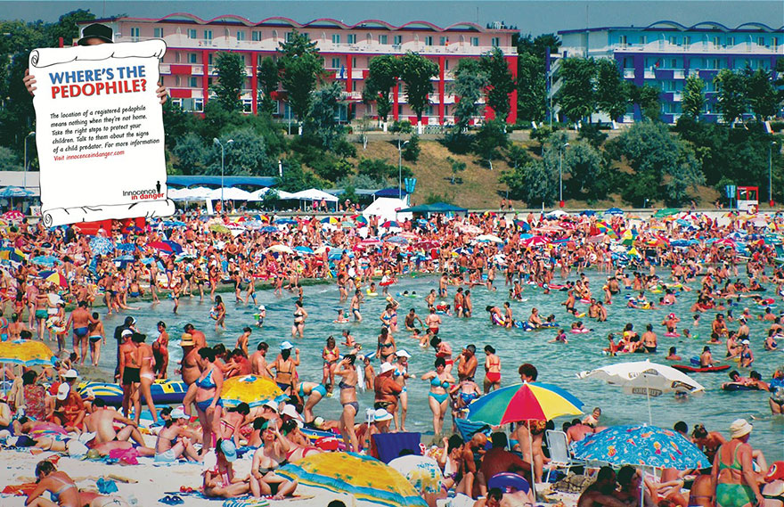 Crowded beach scene with a thought-provoking sign about safety, aiming to raise awareness on protecting children. Crowded beach scene with a thought-provoking sign about safety, aiming to raise awareness on protecting children.