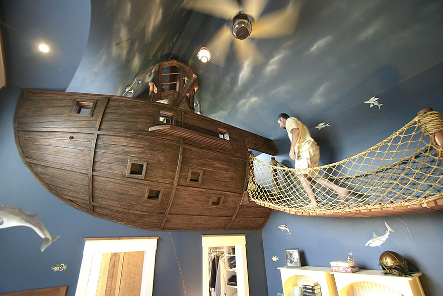 Creative kids room ideas featuring a pirate ship bed and rope bridge in a nautical-themed children's bedroom. Creative kids room ideas featuring a pirate ship bed and rope bridge in a nautical-themed children's bedroom.