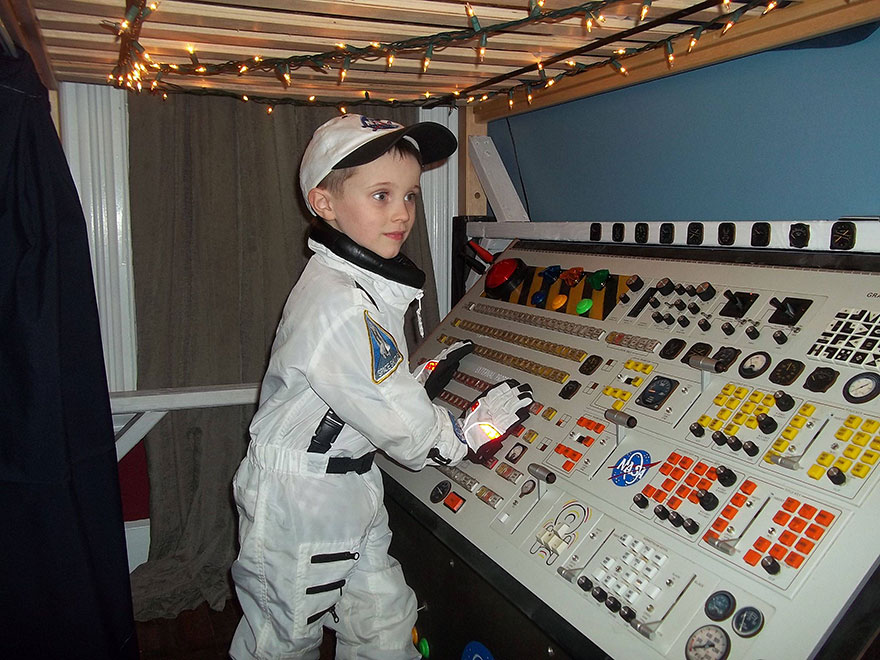 Child dressed as astronaut playing with a space-themed control panel in a creative kids room idea setup. Child dressed as astronaut playing with a space-themed control panel in a creative kids room idea setup.