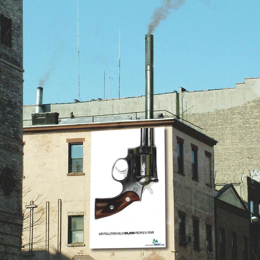 Billboard showing a revolver with a chimney as the barrel, highlighting air pollution's deadly impact. Billboard showing a revolver with a chimney as the barrel, highlighting air pollution's deadly impact.