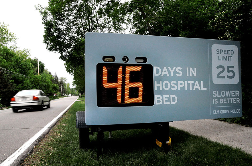 Digital sign on roadside showing "46 days in hospital bed" as car passes, highlighting powerful advertisement message. Digital sign on roadside showing "46 days in hospital bed" as car passes, highlighting powerful advertisement message.