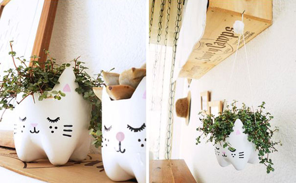 Creative planters made from recycled plastic bottles shaped like cats, holding green plants on a shelf. Creative planters made from recycled plastic bottles shaped like cats, holding green plants on a shelf.