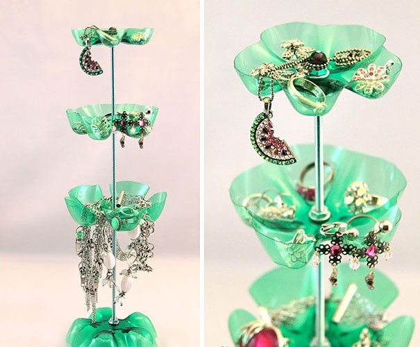 Recycled plastic bottles turned into a three-tiered jewelry holder, showcasing earrings and necklaces. Recycled plastic bottles turned into a three-tiered jewelry holder, showcasing earrings and necklaces.