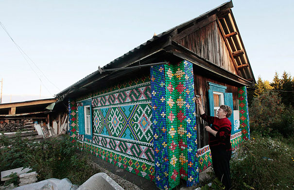 House exterior creatively decorated with recycled old plastic bottles, showcasing a colorful pattern. House exterior creatively decorated with recycled old plastic bottles, showcasing a colorful pattern.