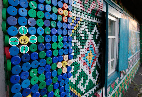 Plastic bottle caps create colorful wall art on a building exterior. Plastic bottle caps create colorful wall art on a building exterior.