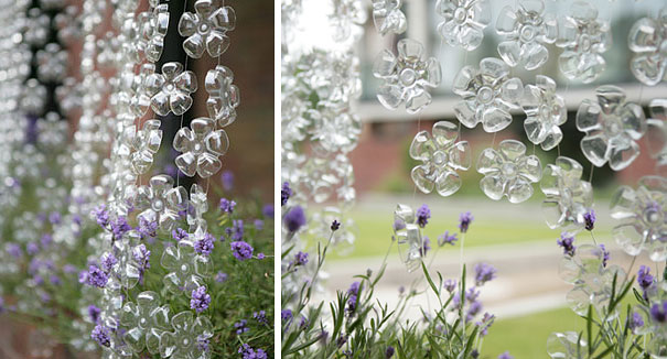 Recycled plastic bottle flowers hanging in a garden setting with purple blooms. Recycled plastic bottle flowers hanging in a garden setting with purple blooms.