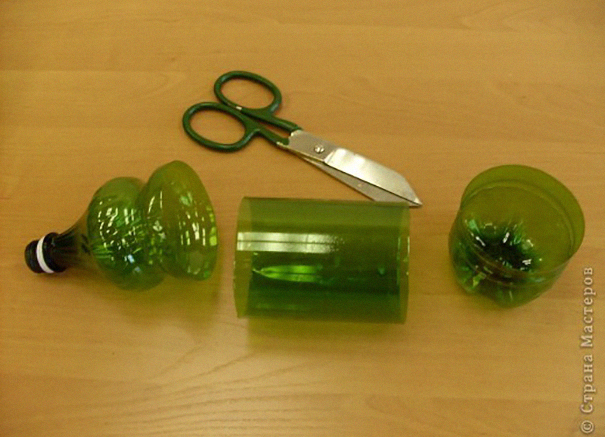 Recycled plastic bottle cut into sections with scissors on wooden surface. Recycled plastic bottle cut into sections with scissors on wooden surface.