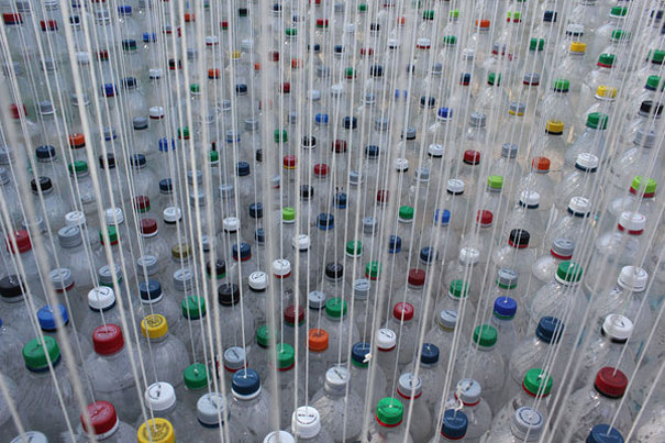 Recycled plastic bottles arranged vertically with colorful caps, creating an artistic installation. Recycled plastic bottles arranged vertically with colorful caps, creating an artistic installation.