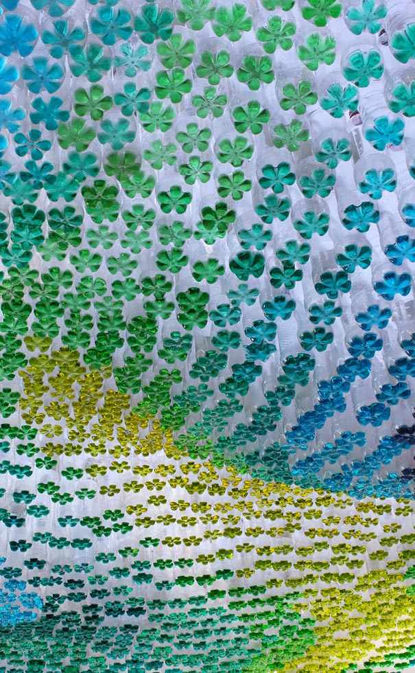 Colorful ceiling art made from recycled old plastic bottles in various shades of blue and green, creating a floral pattern. Colorful ceiling art made from recycled old plastic bottles in various shades of blue and green, creating a floral pattern.
