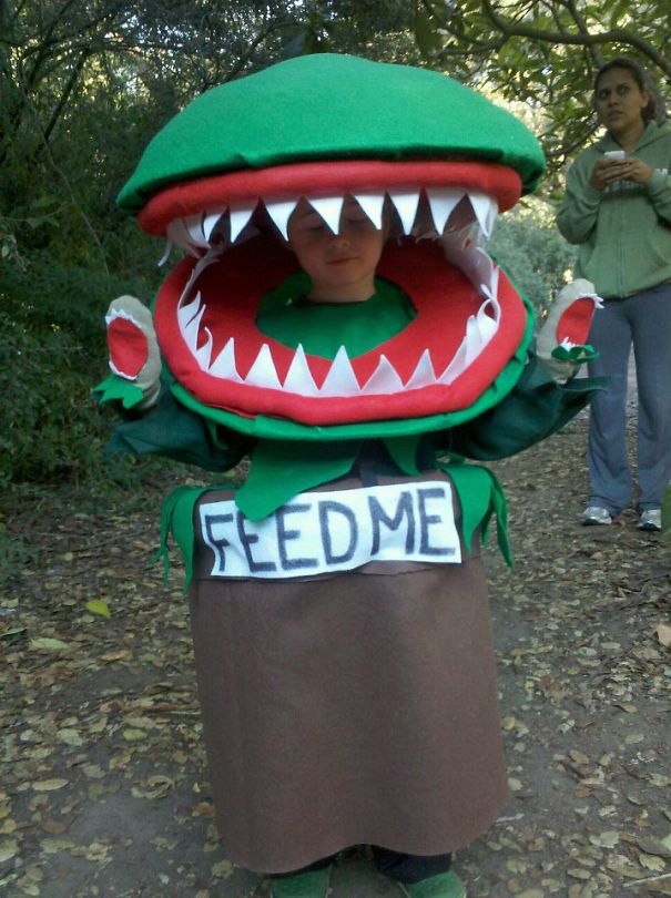 Child wearing a creative plant monster Halloween costume in the woods, perfect for children's Halloween costume ideas.