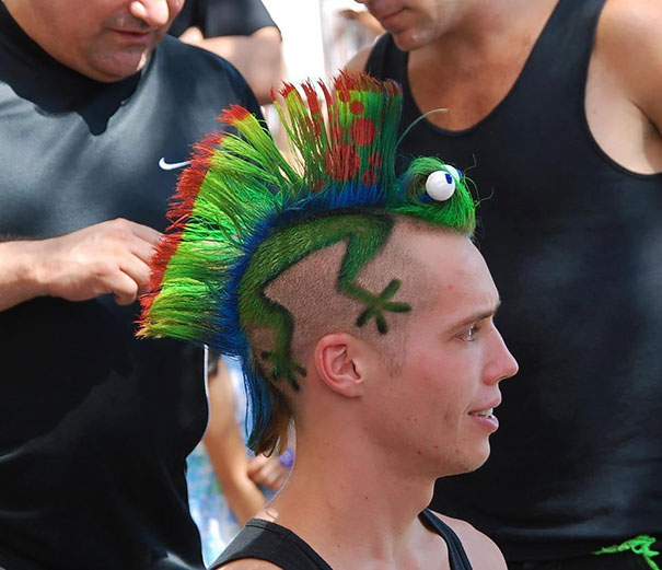 Man with a colorful, lizard-themed Mohawk, showcasing one of the craziest haircuts ever at an outdoor event.