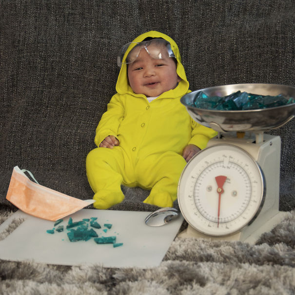 Baby wearing a yellow costume and goggles surrounded by props in a playful scene for children's Halloween costume ideas.