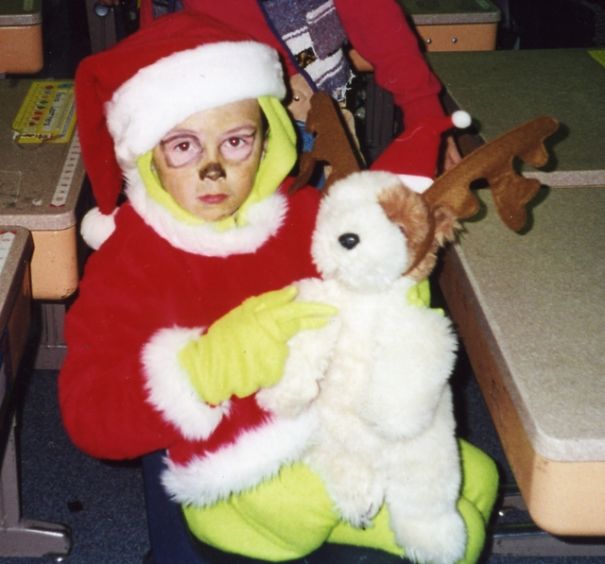 Child in a colorful Halloween costume holding a plush reindeer, showcasing unique children's Halloween costume ideas.