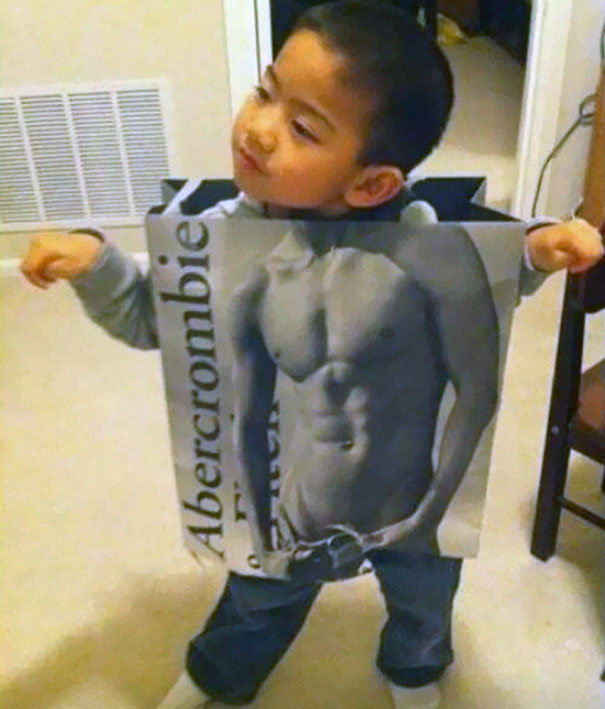 Young child creatively dressed in a Halloween costume with a muscular torso design from a clothing box for kids' costume ideas.