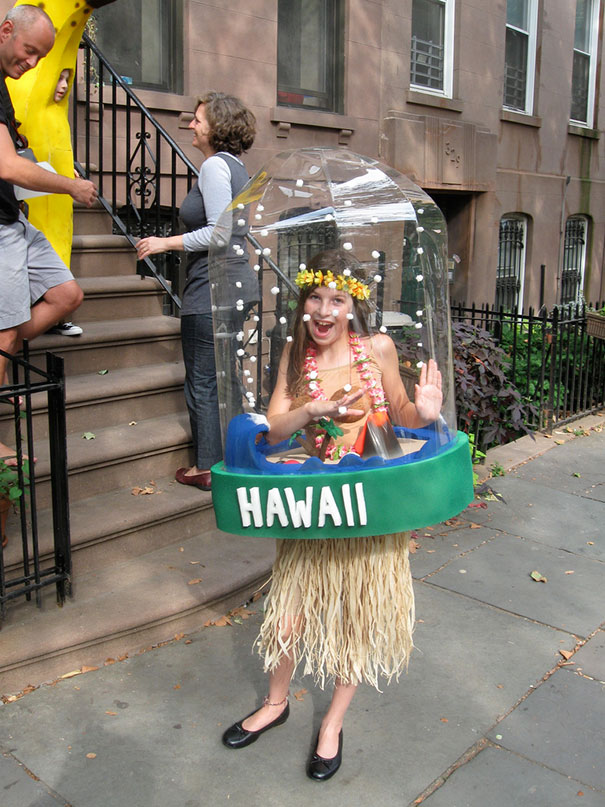 Child in creative Hawaii-themed costume with hula skirt and dome, showcasing unique children's Halloween costume ideas outdoors.