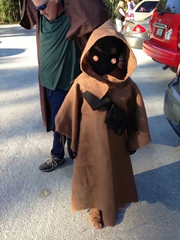 Child wearing a Halloween costume featuring a brown hooded robe and glowing eyes, perfect for children's Halloween costume ideas.