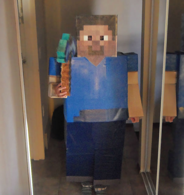 Child wearing a pixelated video game character costume holding a blocky tool, children's Halloween costume ideas inspiration.