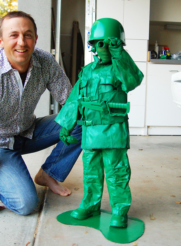 Child dressed as a green army soldier toy costume standing next to smiling adult, children's Halloween costume ideas.