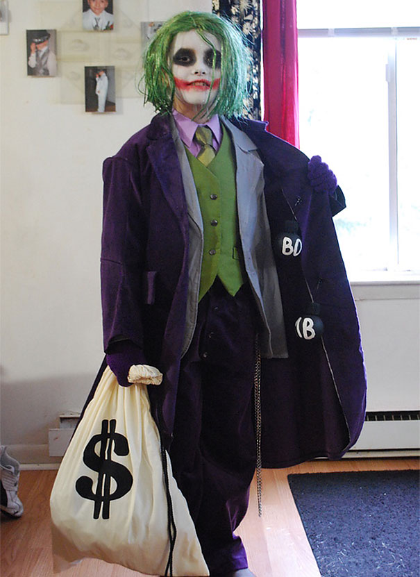 Child dressed in a Joker-style costume holding a money bag, showcasing creative children's Halloween costume ideas.