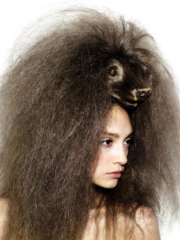A person with a crazy haircut featuring a lion's head sculpted in voluminous, textured hair.
