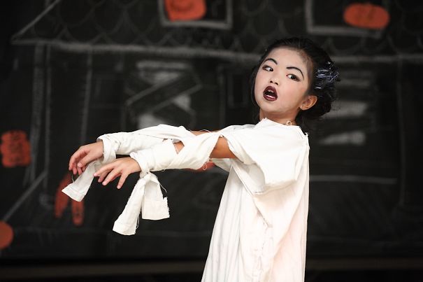 Child dressed in Halloween costume with mummy wrap, posing with arms extended as part of children's Halloween costume ideas.