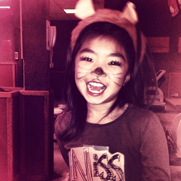 Happy child dressed in a Halloween costume with face paint and animal ears, perfect for children's Halloween costume ideas.