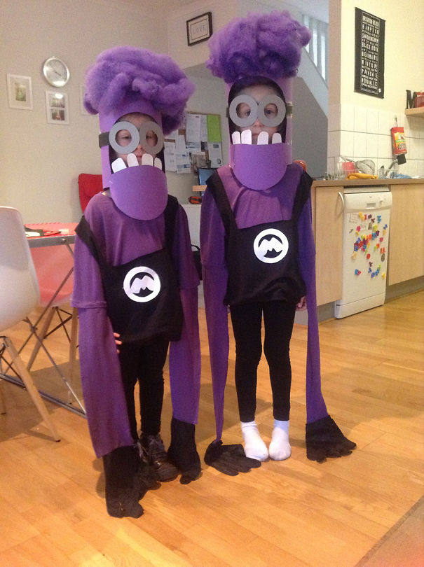 Two children in creative purple Halloween costumes with tall headpieces and long sleeves, perfect for children's Halloween costume ideas.