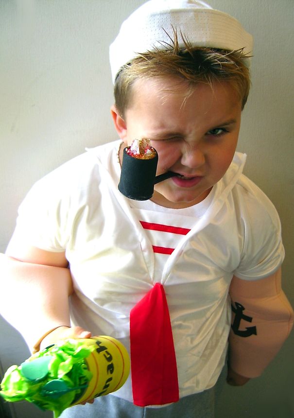 Child dressed as a sailor with a toy pipe and muscle costume, a fun children's Halloween costume idea.