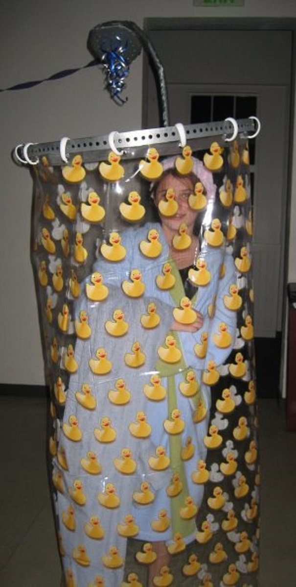 Child wearing a creative children's Halloween costume with a shower curtain decorated with rubber duck stickers.