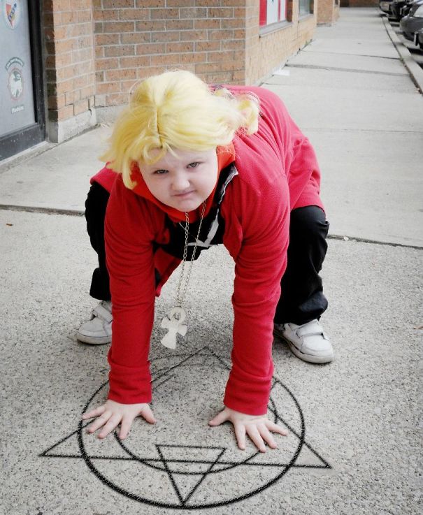 Child wearing a Halloween costume crouching on the sidewalk over a chalk-drawn magical symbol for children’s Halloween costume ideas.