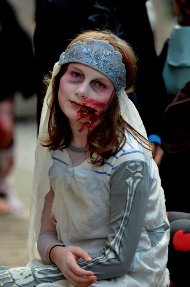 Child in a spooky Halloween costume with skeleton sleeves and a creepy bridal veil as part of children's Halloween costume ideas.