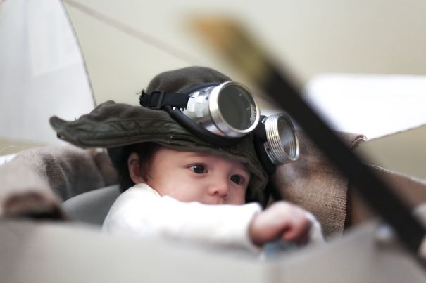 Baby wearing a unique children's Halloween costume with aviator goggles and a hat, showcasing creative costume ideas.