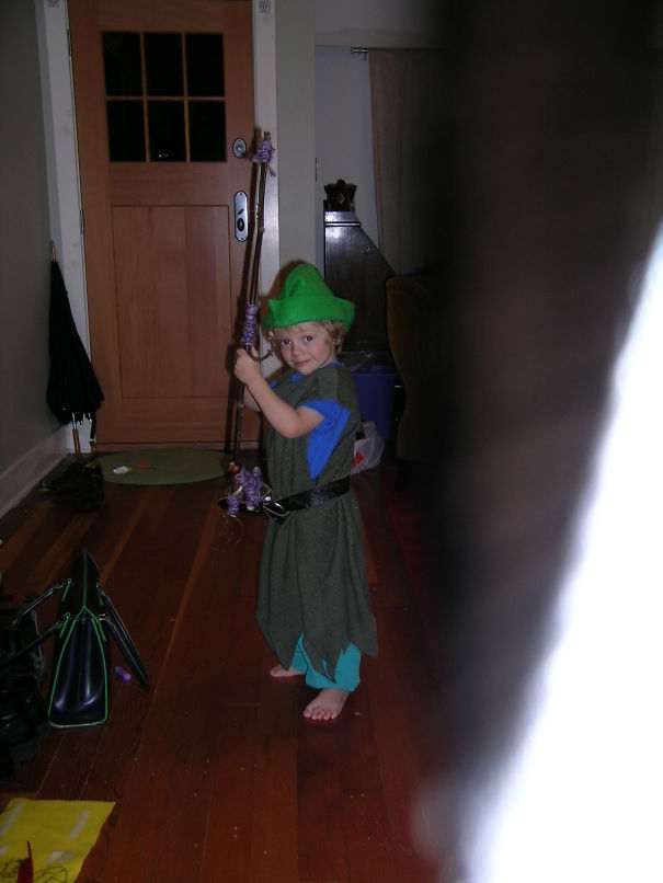 Child dressed in a fantasy costume holding a staff indoors, perfect example for children's Halloween costume ideas.