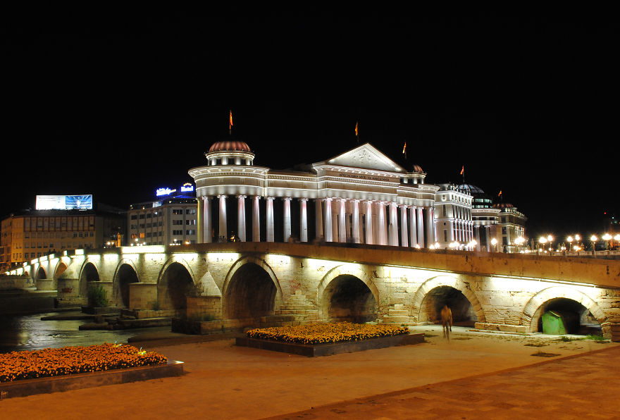 Historic illuminated stone bridge at night with classical architecture, a mystical bridge that transports to another world.