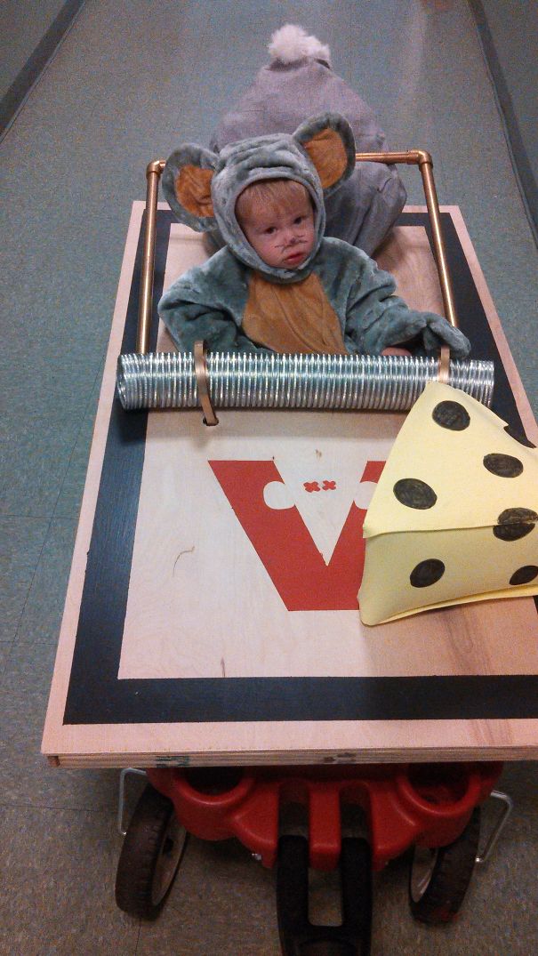 Child in a mouse Halloween costume sitting in a homemade go-kart with a large foam cheese prop for children's Halloween costume ideas.