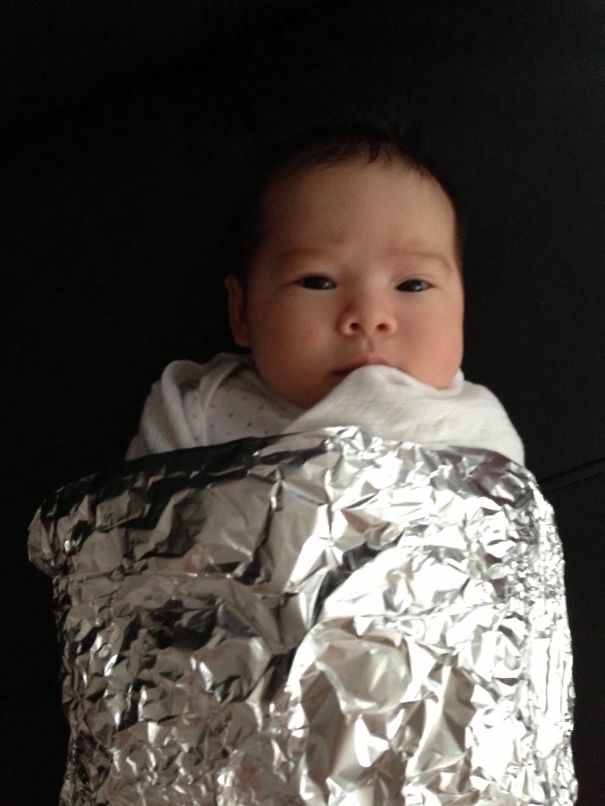 Baby dressed in a creative children's Halloween costume wrapped in shiny foil for Halloween costume ideas.