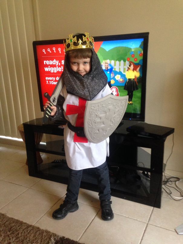 Child dressed as a knight wearing a crown holding a sword and shield, a creative children's Halloween costume idea.