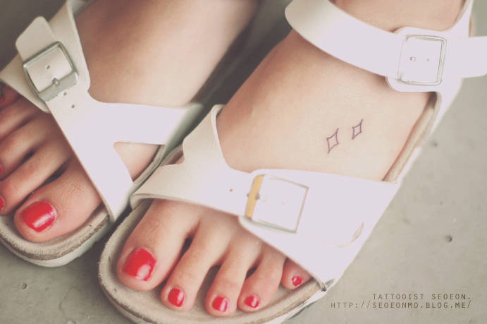 Minimalistic tattoo by Seoeon on foot, discreet design, wearing white sandals with red painted toenails. Minimalistic tattoo by Seoeon on foot, discreet design, wearing white sandals with red painted toenails.
