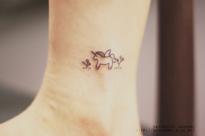 Minimalistic tattoo by Seoeon featuring a small unicorn with flowers on the ankle. Minimalistic tattoo by Seoeon featuring a small unicorn with flowers on the ankle.