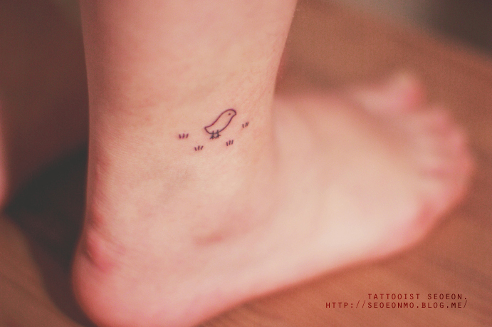 Minimalistic tattoo by Seoeon on an ankle, featuring a small bird design, emphasizing discreet and feminine style. Minimalistic tattoo by Seoeon on an ankle, featuring a small bird design, emphasizing discreet and feminine style.