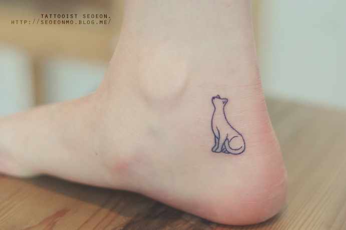 Minimalistic tattoo by Seoeon: a discreet cat outline on a person's ankle. Minimalistic tattoo by Seoeon: a discreet cat outline on a person's ankle.