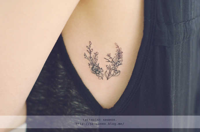 Minimalistic feminine tattoo by Seoeon showing delicate floral design on arm. Minimalistic feminine tattoo by Seoeon showing delicate floral design on arm.