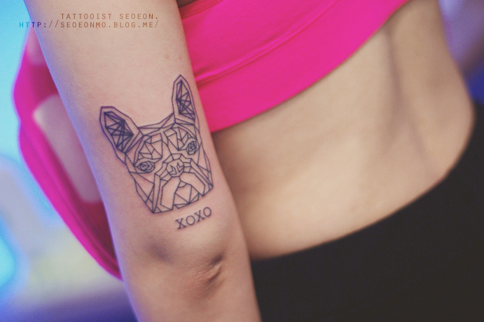 Minimalistic tattoo by Seoeon on arm, featuring geometric dog design and "XOXO" text below. Minimalistic tattoo by Seoeon on arm, featuring geometric dog design and "XOXO" text below.